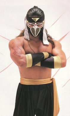 the wrestler is posing with his hands on his hips and wearing a black mask,