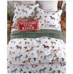 a bed with horses on it and a welcome to the ranch pillow case in red