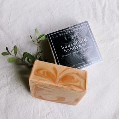 a soap bar sitting on top of a white towel next to a book