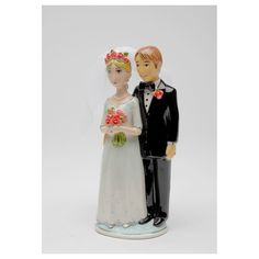 a wedding cake topper with a bride and groom holding flowers in their hands on a white background