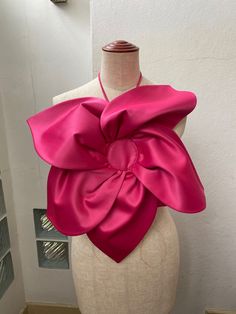 a mannequin with a large pink bow on it's head and neck