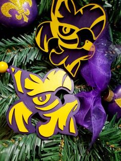 purple and yellow ornaments are hanging from a christmas tree