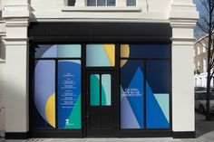 an entrance to a building that has been painted blue, yellow and green with geometric shapes