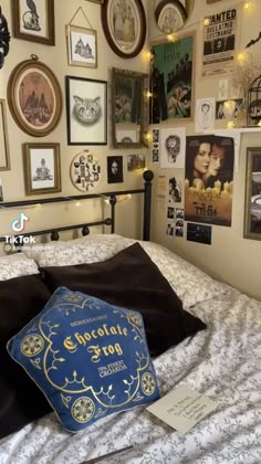 a bed room with a neatly made bed and lots of pictures on the wall