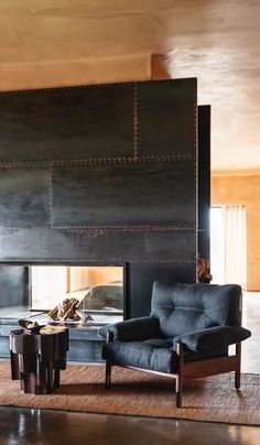 a living room filled with furniture and a fire place in the middle of the room