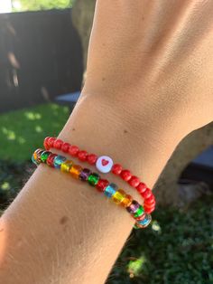 Circular red beads sealed with a heart for lasting luck in love combined with a multi color strand of glass seed beads! - Standard bracelet size is 7 inches. Please message me if you have smaller or larger wrists. Red Colorful Beaded Bracelets For Everyday, Heart-shaped Colorful Beads For Gifts, Everyday Red Jewelry With Colorful Beads, Heart-shaped Letter Beads For Gifts, Red Heart Charm Bracelet For Friendship, Everyday Red Stretch Bracelet With Round Beads, Red Heart Bracelets For Friendship, Red Round Beads Bracelet For Everyday, Red Heart Beads For Gifts