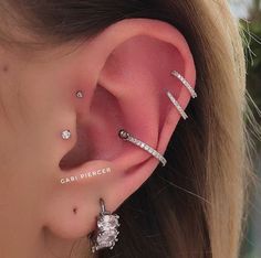 a close up of a person wearing ear piercings with diamonds on the end of their ears