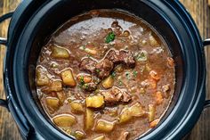 a crock pot filled with stew on top of a table