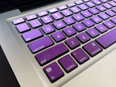 a purple keyboard sitting on top of a laptop computer