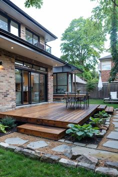 a wooden deck in front of a brick house