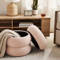 a pink bean bag chair sitting on top of a rug next to a wooden table