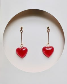 Add some love to your accessory collection with these cute and simple red heart drop earrings. These earrings feature a classic heart shape charm that is made of red resin and hangs from a gold-filled wire. The heart charm is small and dainty, making these earrings a perfect choice for those who prefer a more understated look. These earrings are lightweight and comfortable to wear, making them perfect for everyday wear. The vibrant red color is sure to add a pop of color to any outfit. These ear Cheap Handmade Heart Earrings For Party, Whimsical Cheap Earrings For Valentine's Day, Cheap Statement Jewelry For Valentine's Day, Dangling Earrings Heart, Affordable Quirky Red Earrings, Heart-shaped Romantic Earrings, Cheap Trendy Heart Earrings For Valentine's Day, Valentine's Day Metal Jewelry, Cheap Trendy Earrings For Valentine's Day