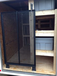 the inside of a trailer with shelves and bins in it's back door