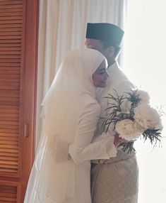 two people in wedding attire standing next to each other