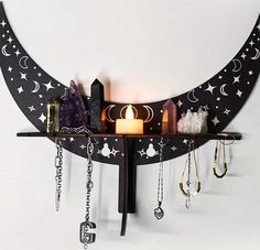 a shelf that has some jewelry on it and a candle in front of the moon