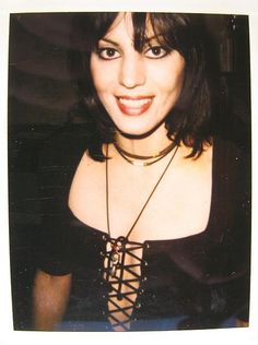 a woman wearing a black top and necklace