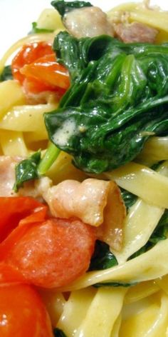 pasta with spinach, chicken and tomatoes on it