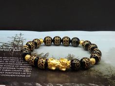 Gift yourself or your loveonce this beautiful Pure Gold Feng Shui Pixiu Bracelet.  *Materials: Au999 Pure Gold, Onyx Stone *Karat: 24K Pure Gold  *Gold Color: Yellow *Gold Weight: Approximately 1.71g - 1.75g SIZE Pixiu Length: .82 Inches Pixiu Width: .38 Inches Mantra Ball: 6mm Onyx Stone: 10mm 🔸️Pi Xiu has the meaning of bringing in wealth and treasure. Of course, it is capable of warding off evil spirits and bringing good fortune.  🔸️Money Ball is used to attract good fortune and money luck, Spiritual Yellow Gold Beaded Bracelets As Gift, Symbolic Gold Bracelets For Festivals, Gold Crystal Bangle Bracelet For Gift, Yellow Gold Bangle Beaded Bracelet Gift, Yellow Gold Beaded Bangle Bracelet Gift, Symbolic Gold Beaded Bracelets As Gift, Spiritual Gold Bangle Bracelet As Gift, Symbolic Gold Beaded Bracelets For Gifts, Spiritual Gold Bracelets For Festivals