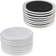 white and black plates stacked on top of each other in front of a white background