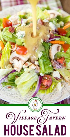 a salad with dressing being drizzled over it and the words village tavern house salad