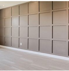 an empty room with wood paneling on the walls