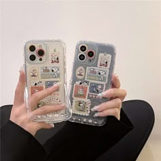 a woman holding two cell phones with stickers on them