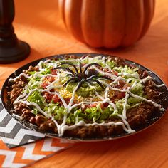 a pizza with cheese, lettuce and other toppings sits on a table