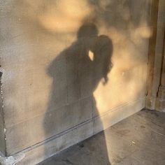 the shadow of a person standing in front of a wall