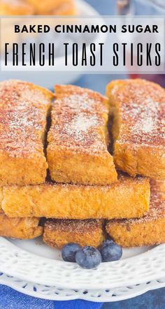 baked cinnamon sugar french toast sticks on a white plate with blueberries and powdered sugar