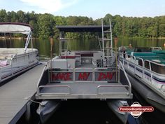 two boats are docked at the dock with one boat that says wake my day