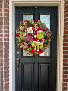 a christmas wreath on the front door of a house with an image of dr seuss