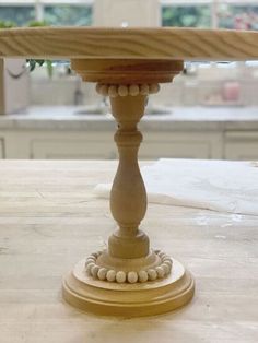 a close up of a cake stand on a kitchen counter with flowers in the background