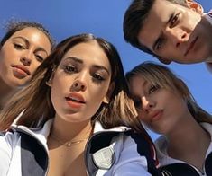 four young women and one man are posing for the camera