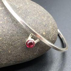 "I designed this simple, elegant and delicate sterling silver bracelet (available in Garnet or Sapphire) for women. in honor of mothers, and grandmothers and sisters, and girlfriends, and wives; in honor of women everywhere! I decided to designed a select number of pieces for women. Don't worry. I still specialize in Jewlery for Men. These are special limited designs for her. More stones varieties coming soon! I hand forged this bracelet in my home studio in Austin, TX. It's made of Sterling sil Modern Garnet Jewelry As A Gift, Modern Garnet Jewelry For Gift, Modern Sterling Silver Bracelet With Gemstone, Minimalist Sterling Silver Hallmarked Bracelet As Gift, Elegant Sterling Silver Bracelet With Birthstone, Mens Onyx Bracelet, Jewelry Sapphire, Garnet Bracelet, Garnet Jewelry