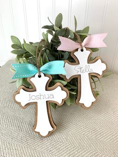 three wooden crosses with name tags on them sitting in front of a potted plant