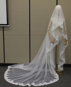 a mannequin wearing a wedding dress with a veil