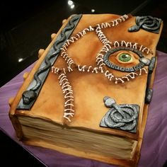 a cake made to look like a book with an eye on it's cover