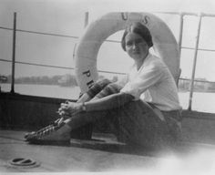 a woman sitting on the deck of a boat with a life preserver in her hand