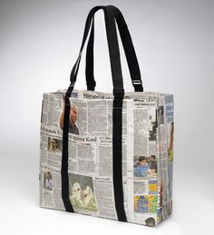 a newspaper tote bag with the front page of news paper printed on it and black straps