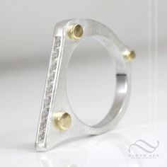 A bold minimalist ring, with a brushed finish, polished gold accents and a row of channel set stones. This ring will stack well with other rings, or can be worn alone. Makes a wonderful anniversary gift, or wedding ring. Made to order! Please allow about 1-2 weeks for your ring to be crafted. Features: ~All rings will feature 9 stones, all 2mm, round brilliant cut, channel set. ~All rings feature polished 18k yellow gold accent droplets on one side ~On the other side are 3 polished divots, direc Earth Art, Minimalist Ring, Channel Set, Gold Accent, Minimalist Rings, Stacking Ring, Ring Sterling Silver, Ring Box, Stacking Rings