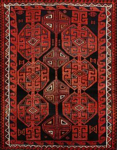 an old red and black rug with geometric designs