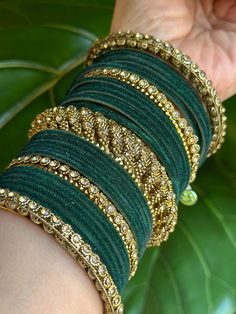 Beautiful dark green and golden color bangles with stone detailing for a classic look. Made of metal and available in a 2.10 size, these bangles are sure to add a touch of elegance to your ensemble.Features:  - Made of metal( 25 bangles) - dark green and golden color - Stone detailing - 2.10 size Green Bangles Hand Pic, Traditional Festive Green Bangle, Festive Traditional Green Bangle, Green Bangle Jewelry For Diwali, Traditional Green Bangle For Festivals, Elegant Green Bangle With Stone Work, Green Stone Work Bracelets For Festivals, Green Bollywood Bracelets For Festivals, Green Bracelets With Stone Work For Festivals