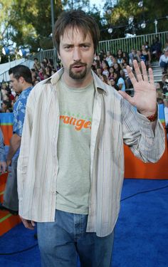 a man standing in front of a crowd with his hand up to the camera and making a stop sign