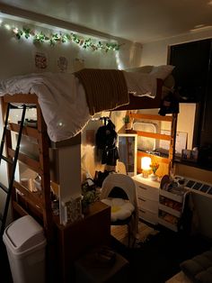 a loft bed with bunk beds in the middle and lights strung from the ceiling above it