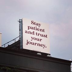 a sign that says stay patient and trust your journey on the roof of a building