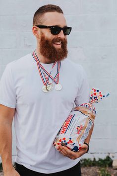 a man with a beard holding a bottle and medal