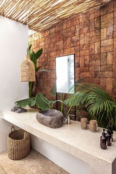 a bathroom with a stone counter top and plants on the wall, along with two mirrors