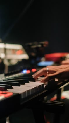 a person is playing the piano in front of some other musical instruments and lights at night