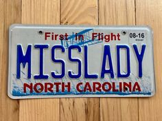 a license plate that reads, first in flight, miss lady north carolina on a wooden background