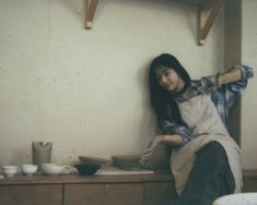 a woman in an apron is making bowls